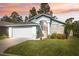 House exterior at sunset, light blue with white garage door at 7940 Fashion Loop, New Port Richey, FL 34654