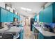 Open concept kitchen with teal cabinets and stainless steel appliances at 7940 Fashion Loop, New Port Richey, FL 34654
