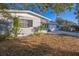 Side view of the house showing mature trees and landscaping at 11357 116Th Ave, Largo, FL 33778