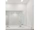 Bathroom featuring double sinks with quartz countertops and large mirrors above, alongside a tiled shower at 14033 Crutchfield Ct, Parrish, FL 34219