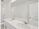 A clean bathroom with a double sink vanity and a framed mirror at 14033 Crutchfield Ct, Parrish, FL 34219