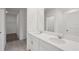 Bright bathroom featuring double sinks with modern fixtures, elegant vanity, and a view into the walk-in closet at 14033 Crutchfield Ct, Parrish, FL 34219