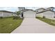 Home exterior features a two-car garage, driveway, manicured lawn, and tasteful landscaping at 14033 Crutchfield Ct, Parrish, FL 34219