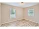 Well-lit bedroom with wood-look floors and two windows at 6445 Skyline Ct, Spring Hill, FL 34606
