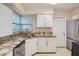 Modern kitchen with white cabinets, granite counters, and stainless steel appliances at 6445 Skyline Ct, Spring Hill, FL 34606