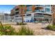 Beautiful exterior with beachside seating and view from ground level featuring palm trees and flowers at 1129 Seaside Dr # 7, Sarasota, FL 34242
