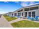 Charming coastal cottages with blue accents and inviting outdoor seating and well-maintained lawn at 1129 Seaside Dr # 7, Sarasota, FL 34242