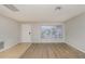 Bright living room featuring light wood-look flooring and a large window at 8018 Idle Briar Ln, Port Richey, FL 34668
