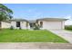 Single-story house with white exterior, attached garage, and green lawn at 8018 Idle Briar Ln, Port Richey, FL 34668