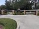 Gated community entrance featuring stone pillars and lush landscaping for a secure and welcoming environment at 23713 Acorn Hill Dr, Lutz, FL 33559