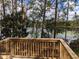 A wooden deck has serene views of a wooded area and pond with lily pads at 23713 Acorn Hill Dr, Lutz, FL 33559