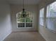 Bright dining room with a chandelier, large window, and tile flooring at 23713 Acorn Hill Dr, Lutz, FL 33559
