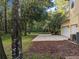 Large driveway with a two-car garage and lush landscaping at 23713 Acorn Hill Dr, Lutz, FL 33559