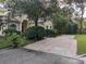 Charming home with a large front yard, mature trees, and a brick driveway at 23713 Acorn Hill Dr, Lutz, FL 33559