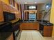 Spacious kitchen with tile flooring, black appliances, granite counters, and wood cabinetry at 23713 Acorn Hill Dr, Lutz, FL 33559