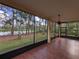 Relaxing screened-in lanai with tile flooring, ceiling fan and serene views of the lush backyard and pond at 23713 Acorn Hill Dr, Lutz, FL 33559