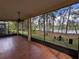 Relaxing screened-in lanai with tile flooring, ceiling fan and serene views of the lush backyard and pond at 23713 Acorn Hill Dr, Lutz, FL 33559