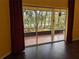 Open living room with hardwood floors and access to screened in lanai with views of the lush backyard and pond at 23713 Acorn Hill Dr, Lutz, FL 33559