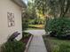 Landscaped side yard with mature trees and view of the water at 23713 Acorn Hill Dr, Lutz, FL 33559