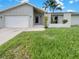 House exterior featuring a single-story home with a two-car garage and manicured lawn at 18978 Mcgrath Cir, Port Charlotte, FL 33948