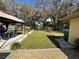 Large backyard with lush lawn, trees, and patio area at 20102 Lorenzo Ave, Port Charlotte, FL 33952