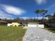 Bright yellow house with gray paver driveway and white fence, offering curb appeal at 20102 Lorenzo Ave, Port Charlotte, FL 33952