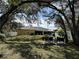 Spacious backyard with patio furniture, mature trees, and a large grassy area at 20102 Lorenzo Ave, Port Charlotte, FL 33952