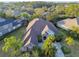 Aerial view of a single-Gathering home featuring lush landscaping, a long driveway, and a neutral color palette exterior at 11909 Mandevilla Ct, Tampa, FL 33626