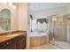 Bright bathroom featuring a soaking tub, separate shower, and granite countertops for a luxurious feel at 11909 Mandevilla Ct, Tampa, FL 33626