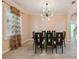 Dining area featuring dark wood table, seating, decorative light fixture and a window with blinds at 11909 Mandevilla Ct, Tampa, FL 33626