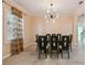 Elegant dining room with decorative crown molding, modern light fixture and window with curtains at 11909 Mandevilla Ct, Tampa, FL 33626