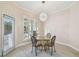 Cozy dining room featuring a modern chandelier and serene views through shuttered windows at 11909 Mandevilla Ct, Tampa, FL 33626