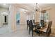 Dining room with modern light fixture, table with seating, and light wood-look tile floor at 11909 Mandevilla Ct, Tampa, FL 33626