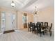 Bright dining room features a modern light fixture and a dark wood table with seating for eight at 11909 Mandevilla Ct, Tampa, FL 33626