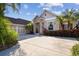 Charming home exterior featuring a brick and stone accent, a well-manicured lawn, and an attached two car garage at 11909 Mandevilla Ct, Tampa, FL 33626