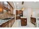Spacious kitchen features dark wood cabinets, tile backsplash, granite countertops, and a center island with modern appliances at 11909 Mandevilla Ct, Tampa, FL 33626