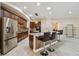 Modern kitchen showcases brown cabinets, backsplash, stainless appliances, granite counters, pendant lights, and bar seating at 11909 Mandevilla Ct, Tampa, FL 33626