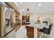 Bright kitchen with stainless steel refrigerator, granite counters, pendant lighting, and white tile flooring at 11909 Mandevilla Ct, Tampa, FL 33626