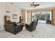 Bright living room with a ceiling fan that offers a view of the pool area through large sliding glass doors at 11909 Mandevilla Ct, Tampa, FL 33626