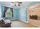 The office has blue walls and wood floors with a couch and a window with a view of the exterior at 11909 Mandevilla Ct, Tampa, FL 33626