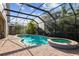 Screened-in pool area with a spa, stone pavers, and lush landscaping offering a private outdoor oasis at 11909 Mandevilla Ct, Tampa, FL 33626