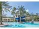 Beautiful swimming pool with blue water slide, palm trees, white pergola and a two-story building with a balcony at 11909 Mandevilla Ct, Tampa, FL 33626