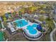 Aerial view of a luxury community pool, tennis court, and clubhouse surrounded by lush landscaping and tropical trees at 11909 Mandevilla Ct, Tampa, FL 33626