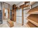 Spacious walk-in closet with custom wood shelving and a comfortable bench for dressing at 11909 Mandevilla Ct, Tampa, FL 33626
