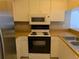 Well-lit kitchen with white cabinets, modern appliances, and warm wood countertops providing a functional space at 642 Bird Bay E Dr # 205, Venice, FL 34285