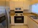 Traditional kitchen features white cabinetry, modern stainless steel refrigerator, and laminated countertops at 642 Bird Bay E Dr # 205, Venice, FL 34285
