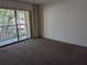 Spacious living room with neutral carpet and sliding glass doors to a balcony at 642 Bird Bay E Dr # 205, Venice, FL 34285