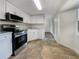 Modern kitchen featuring white cabinets, stainless steel appliances, and tile flooring at 290 Dragon Rd, Venice, FL 34293