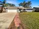 Updated exterior of the home features a newly paved driveway and walkway leading to the front entrance at 4143 Waikiki Dr, Sarasota, FL 34241