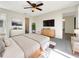 Main bedroom with carpeted floor, a walk-in closet and large TV at 4143 Waikiki Dr, Sarasota, FL 34241
